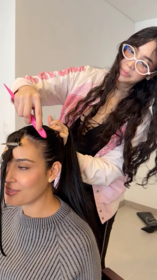 Sara peinando a una clienta